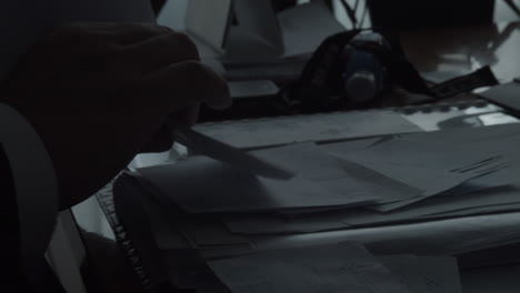 hands of a man picking documents from an office desk