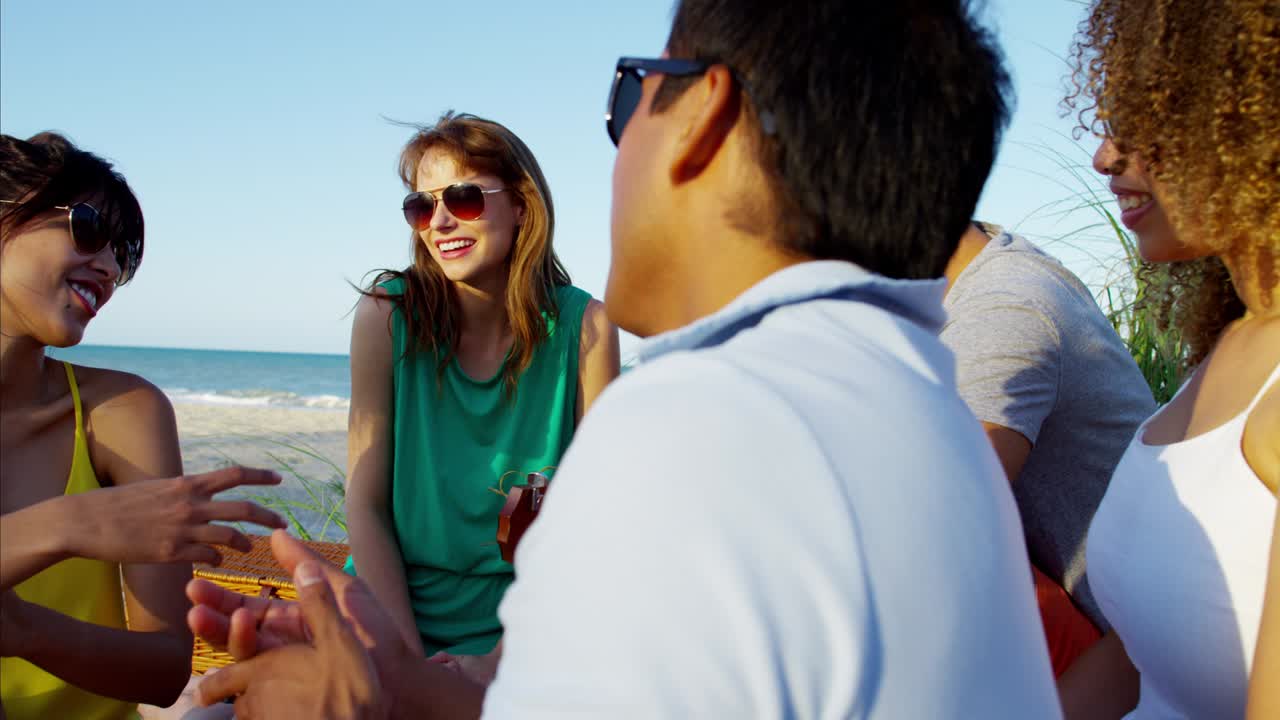 해변 파티에서 기타를 연주하는 백인 미국인 남성