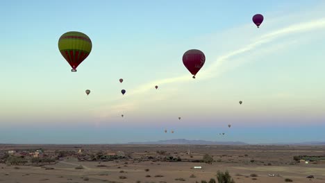 the morning sky over the moroccan desert is full of colourful hot air balloons