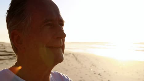 Smiling-senior-man-standing-on-beach