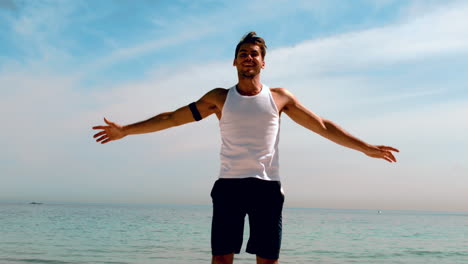 sportsman doing jumping jacks on the beach