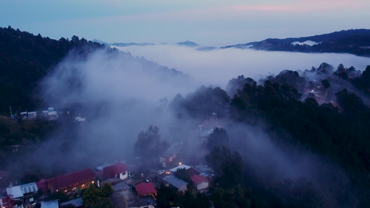 Droneudsigt over en tåget bjerglandsby i skumringen i San José del Pacífico, Oaxaca, Mexico.