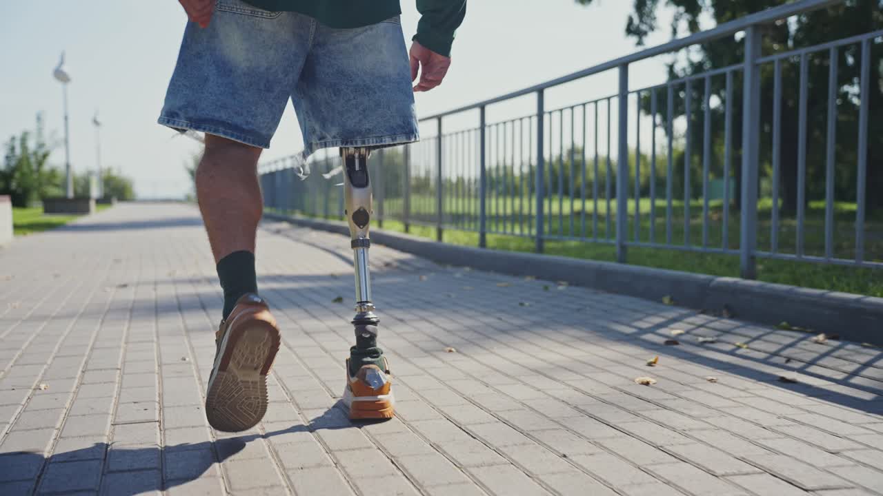 Person with prosthetic leg walking in a park