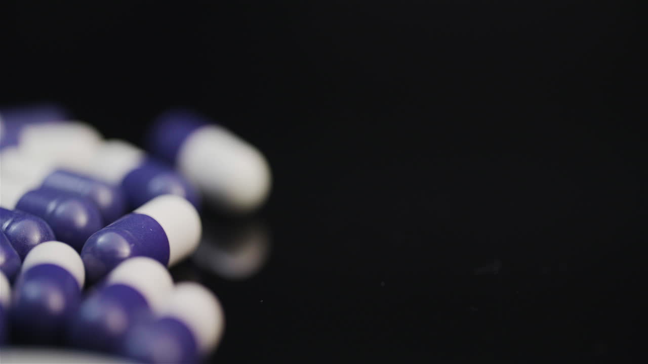 concepto de farmacia de medicina un primerísimo plano de pastillas con antibiótico girando sobre fondo negro