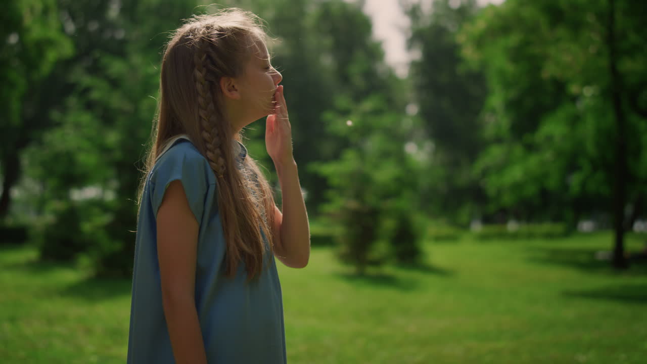 그린 파크 클로즈업에서 어린 소녀의 얼굴을 만져보세요.  ⁇ 빛에 코를  ⁇ 는 아이.