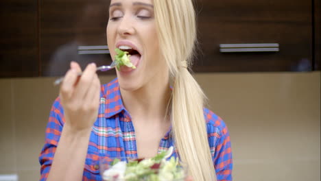 mulher loira feliz comendo salada de vegetais saudável