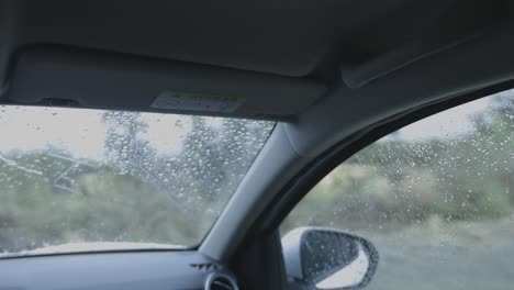 Un-Conductor-Masculino-Conduce-Y-Gira-A-La-Izquierda-En-Un-Camino-De-Tierra-Bajo-La-Lluvia