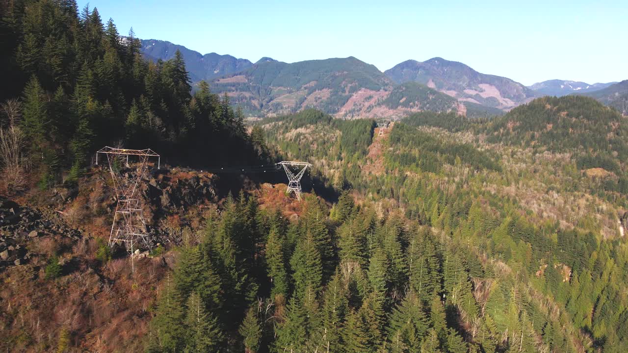 캐나다 브리티시 컬럼비아에 있는 본토 하부의 프레이저 계곡에서 화창한 날 산을 가로지르는 전력선의 일광 장면
