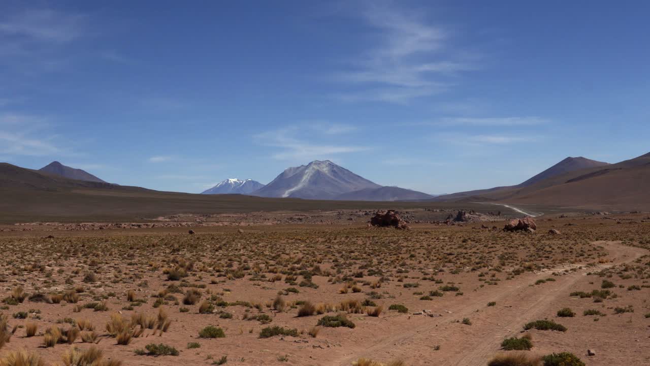 Establishing of Ollague Volcano in Bolivia, with rugged peaks and a dramatic landscape towering over dusty scrub desert