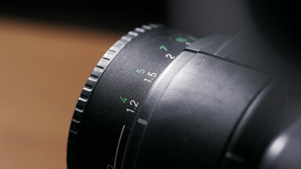 Close up of lens focus ring rotating across distance scale back and forth