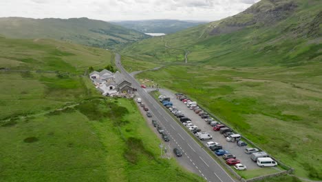 kirkstone pass summit with view down towards lake windermere. the kirkstone pass inn next to the a592 and busy car park. summer. lake district, cumbria, uk