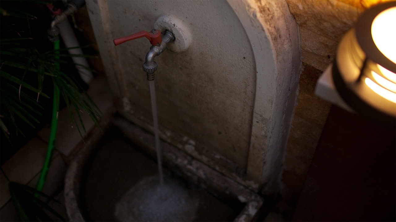 Father washing sand off his son legs