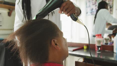 african man styling the hair of a african woman