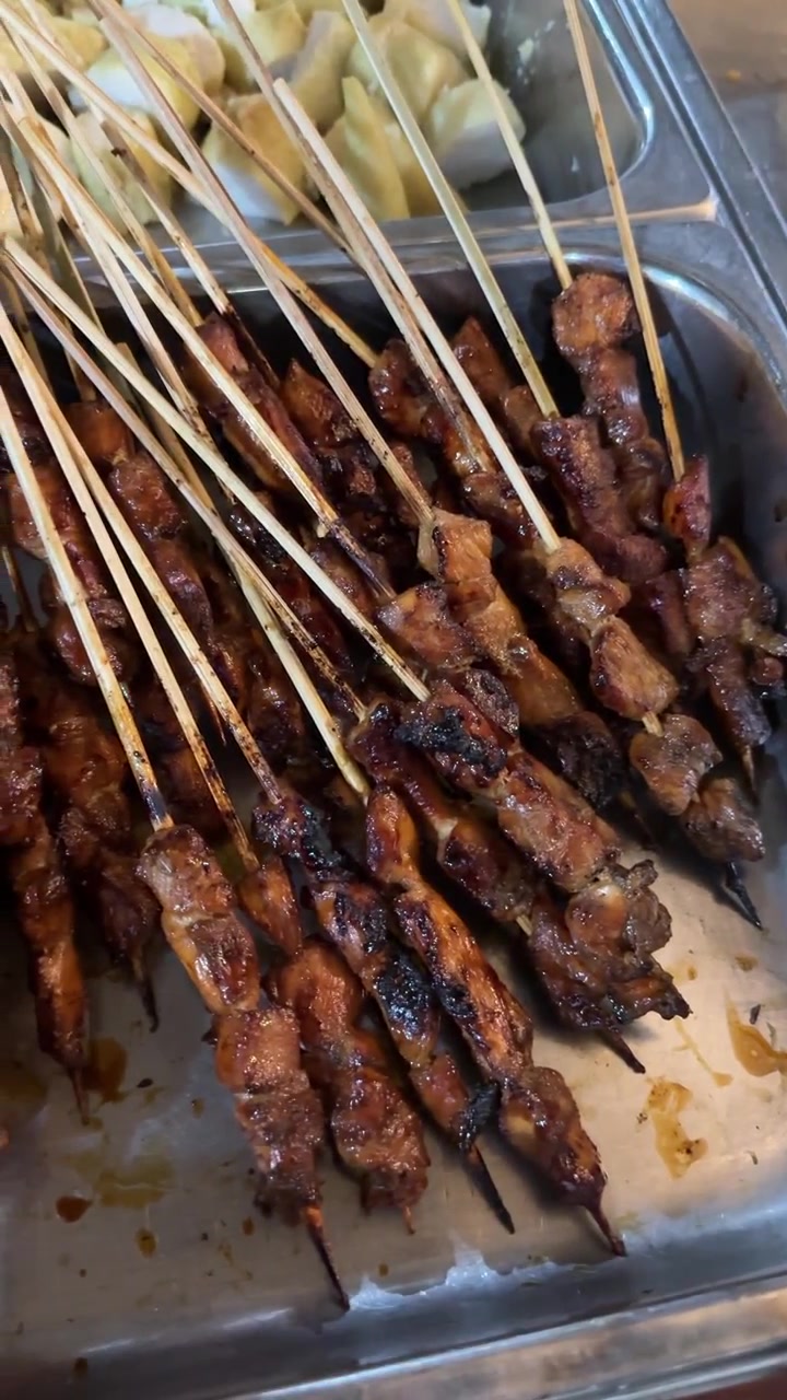 Vastagrillatut kana satay -vartaat metallisissa tarjoiluvadeissa