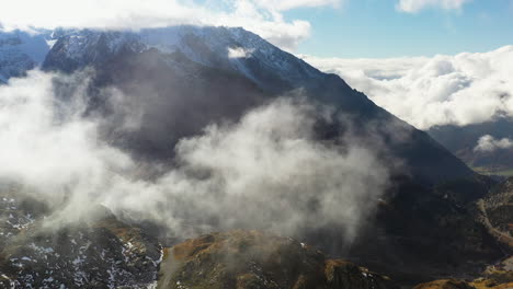 Filmische-Drohnenaufnahme,-Die-Durch-Die-Wolken-Fliegt-Und-Dann-Entlang-Des-Sustenpasses-Zum-Steinsee-Neigt,-Schweiz