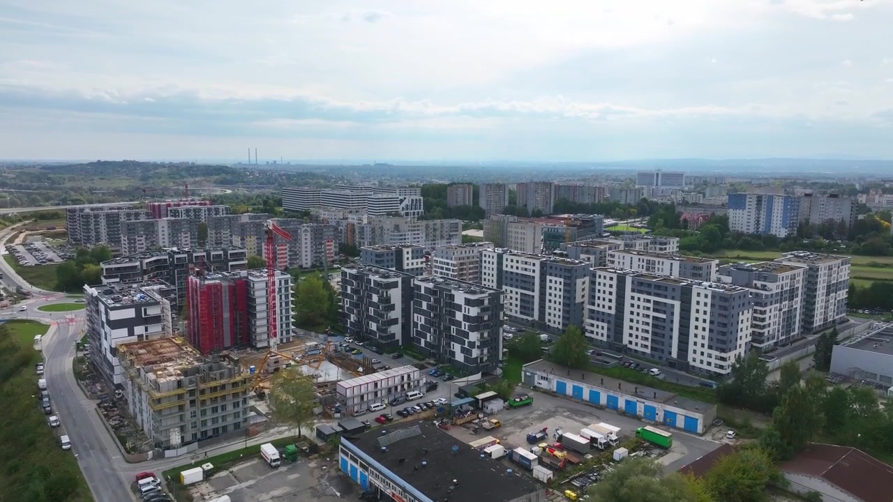 Quay từ trên cao nghiêng lên tiết lộ khu phức hợp căn hộ dân cư hiện đại và công trường xây dựng ở Krakow