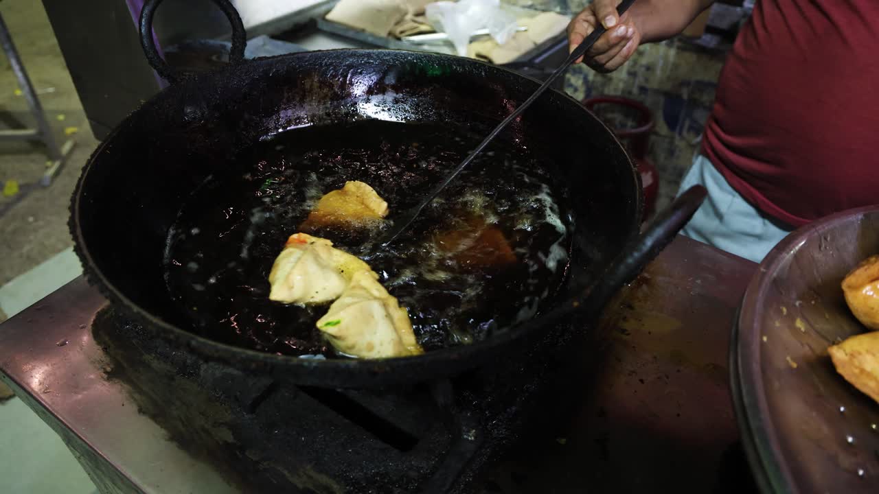 deep oil frying of indian snack samosa at restaurant