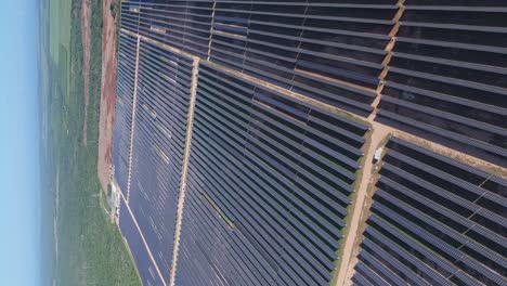 Vertical-backwards-flight-over-large-solar-panel-park-with-units-in-La-Romana,-Dominican-Republic