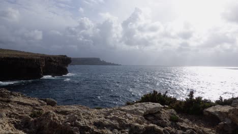 Klippe-Mit-Blick-Auf-Das-Blaue-Meer-Mit-Farbigen-Ballons,-Die-Von-Den-Wellen-Und-Weißen-Wolken-Geführt-Werden,-Zeitraffer-Full-HD-30fps