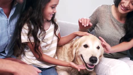 Süße-Familie-Streichelt-Einen-Hund-Im-Wohnzimmer