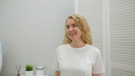 client enters modern salon with cheerful smile, looking toward beautician while engaging warmly. bright setting includes clean white interior and green wall with illuminated sign visible in background