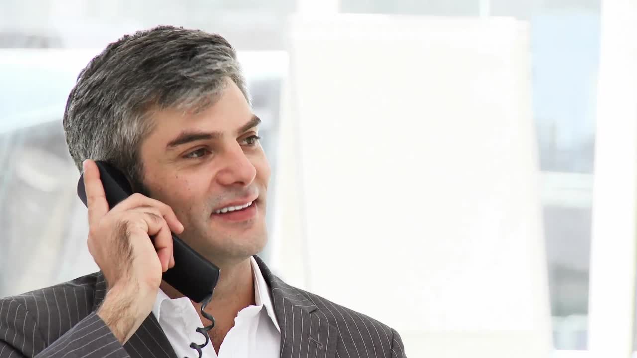 Empresário entusiasmado falando ao telefone