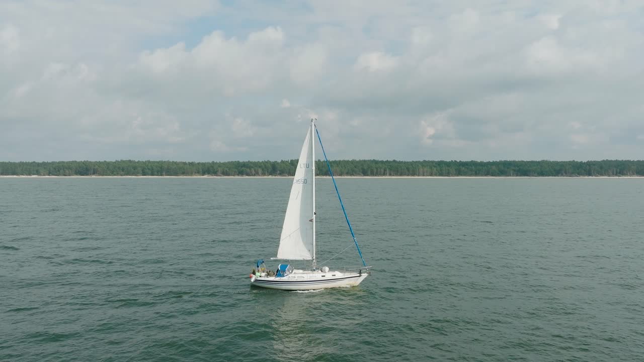 vista aérea de un velero blanco en el tranquilo mar báltico, yate de vela blanco en medio del mar sin límites, día soleado de verano, amplia toma de dolly en movimiento a la derecha