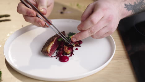 duck breast being plated by a chef