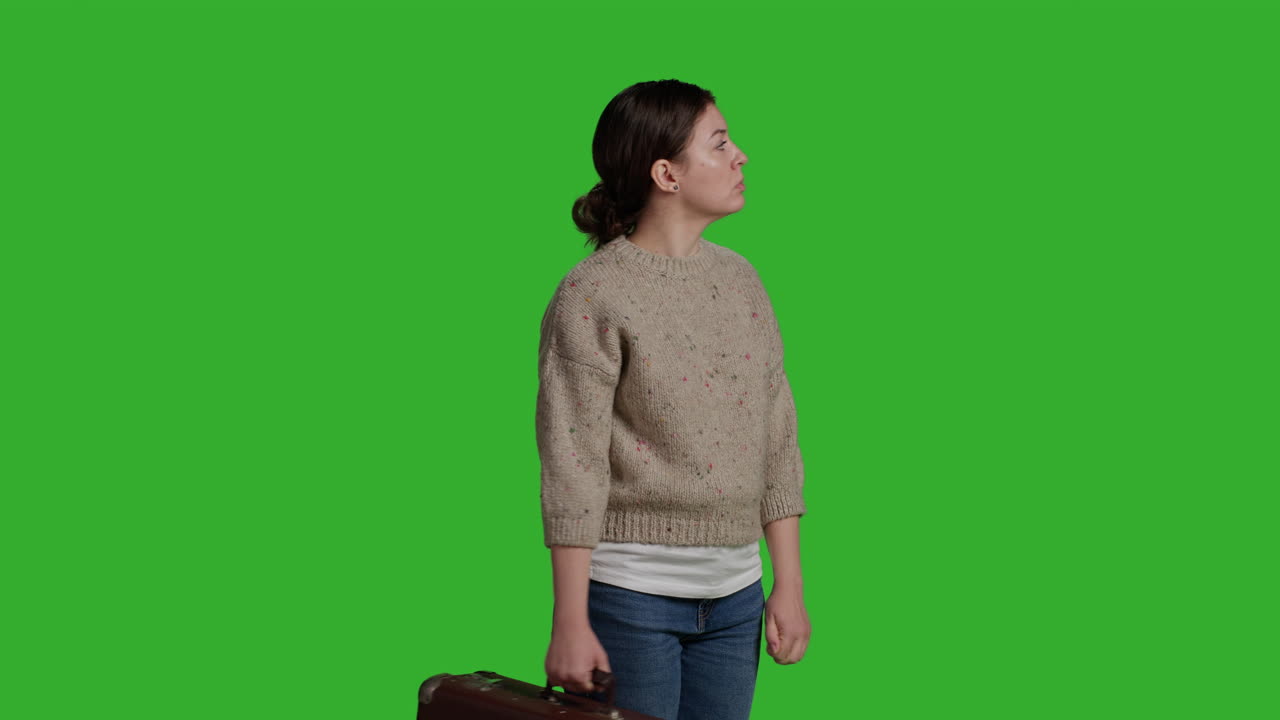 Woman holding a suitcase on green screen
