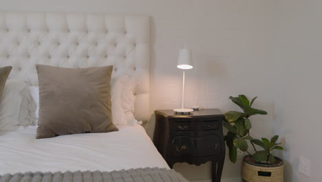 cozy bedroom with elegant decor, featuring plush pillows and bedside lamp, at home
