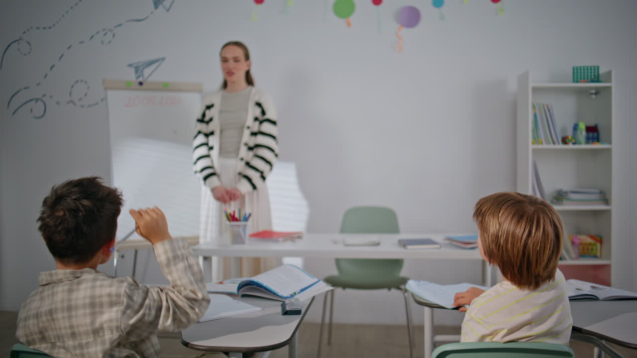 Smiling teacher having lesson at school with students. Schoolteacher explaining