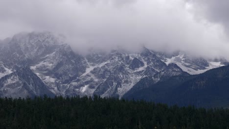 Nubes-Brumosas-Sobre-Bosques-Densos-Y-Montañas-Nevadas