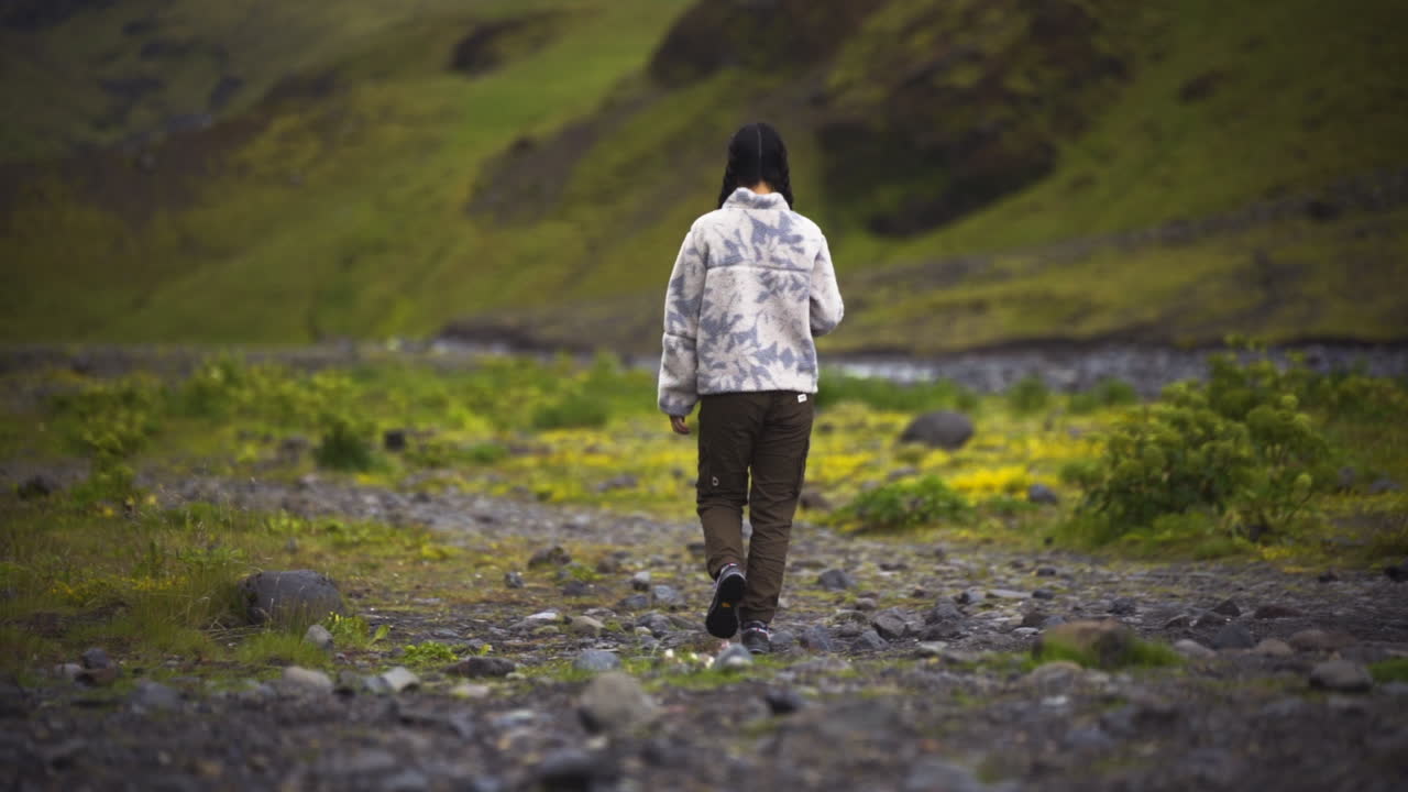 Rear Of A Woman Walking Towards The Valley In Iceland. Slow Motion Shot