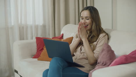 happy woman looking laptop computer at home