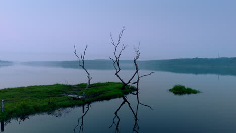 Morgens-Ruhiger-See,-Vor-Sonnenaufgang-Spiegelt-Sich-Der-See-In-Den-Atmosphärischen-Effekten-Des-Himmels-Und-Ist-Von-Nebligen-Nebeln-Umgeben