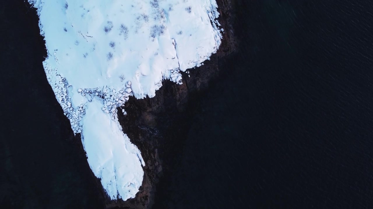 Ripresa aerea con drone dall'alto di ghiaccio alla deriva e costa ghiacciata nella Norvegia artica. Trama invernale astratta delle gelide acque oceaniche vicino alle Isole Lofoten durante la stagione invernale.