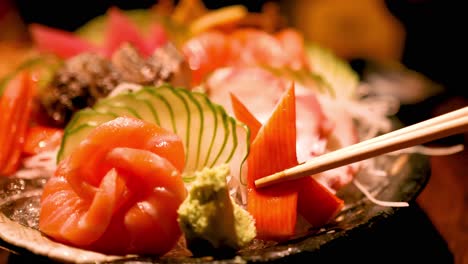 chopsticks picking sashimi from a vibrant platter