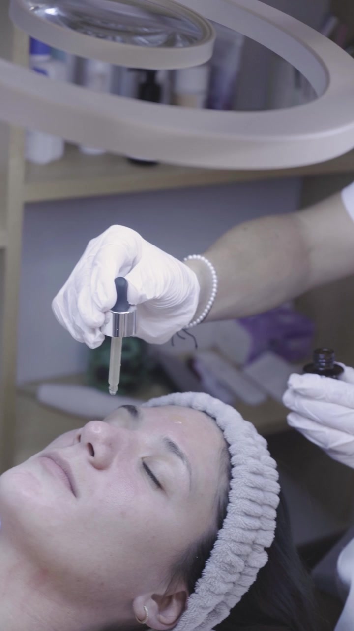 Un applicatore preciso scivola delicatamente lungo la palpebra in una tranquilla sessione di cura della pelle