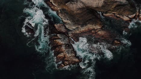 Vista-Aérea-De-Las-Olas-Que-Salpican-En-La-Costa-Rocosa-En-La-Playa-Mazunte-En-Oaxaca,-México