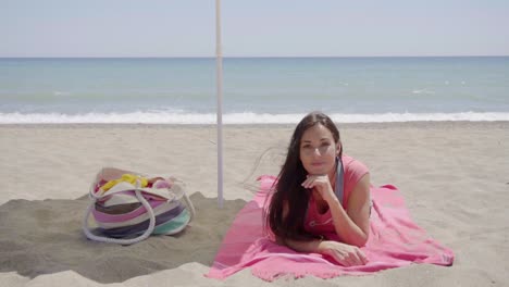 cute woman laying down on beach blanket