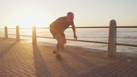 älterer mann bindet seine schnürsenkel an der promenade