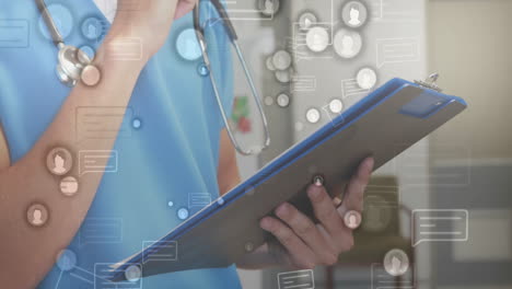 Animation of media icons over caucasian female doctor writing