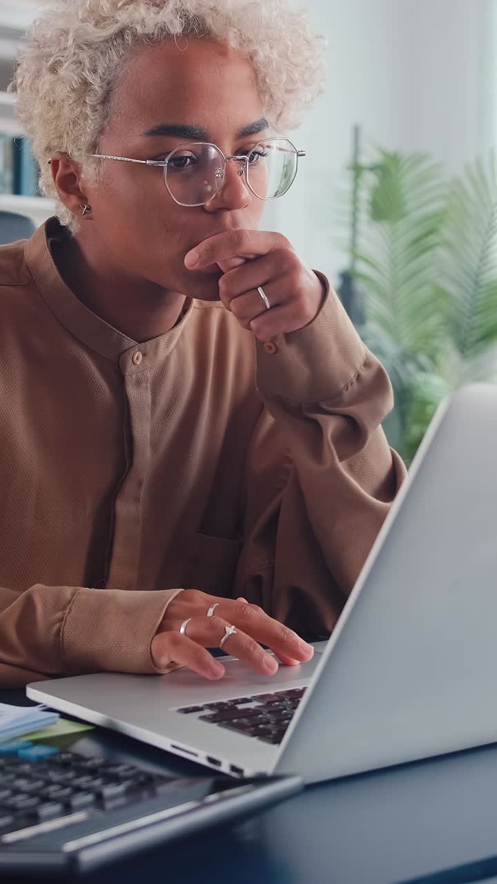 Young puzzled african american woman accountant upset after using calculator