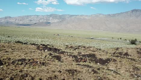 Cinematic-Tilt-Up-Aerial-View-on-Interstate-Highway-With-Vehicles-Under-Alabama-Hills,-California-USA