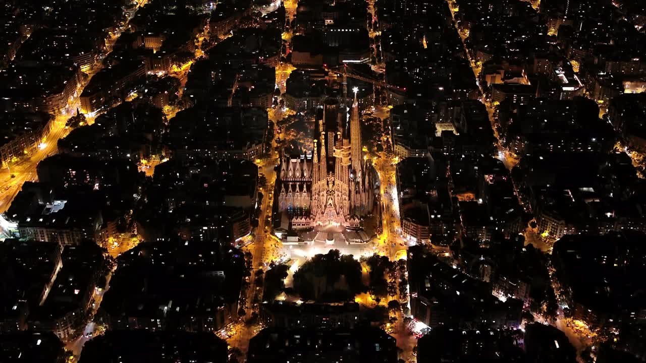 воздушный вид барселоны и примера жилого района и знаменитой базилики sagrada familia ночью. каталония, испания