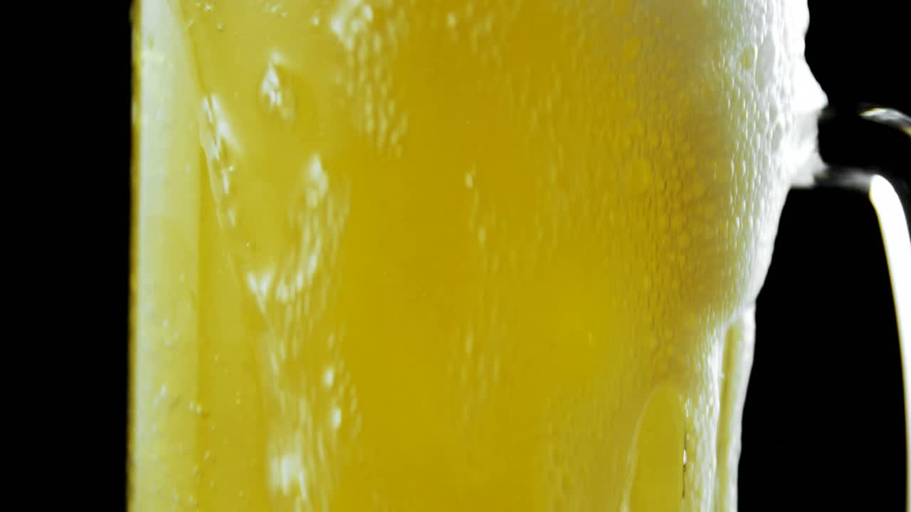 Beer poured in beer mug against black background 4k