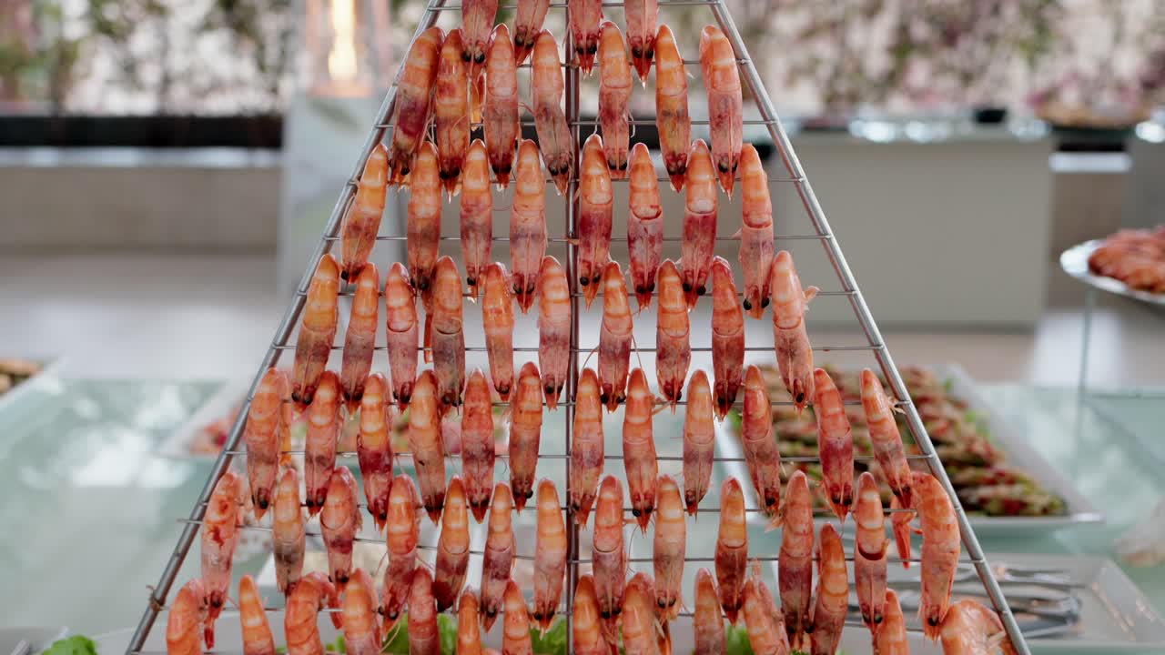 Gamberi cotti disposti su spiedini in un allestimento di presentazione di frutti di mare a buffet