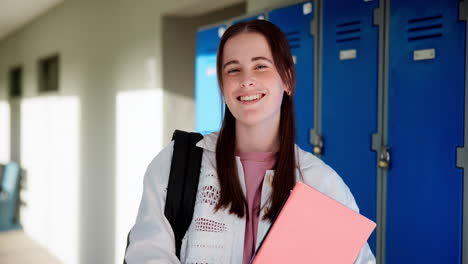 portrait of a smiling female student in a school hallway