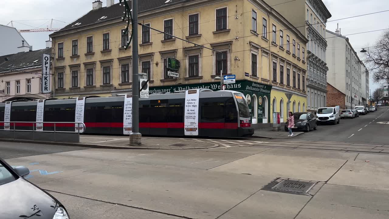 Tram in Vienna moves from right to left and stops at the station, Austria, Europe, following shot from the side