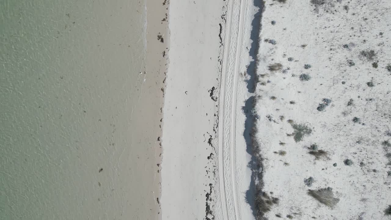 포르투갈의 알렌테조 지역에서 바다에 의해 부드럽게 키스되는 모래 해안의 공중 뷰를 포착하여 평화롭고 그림 같은 해안 장면을 만 ⁇ 니다.